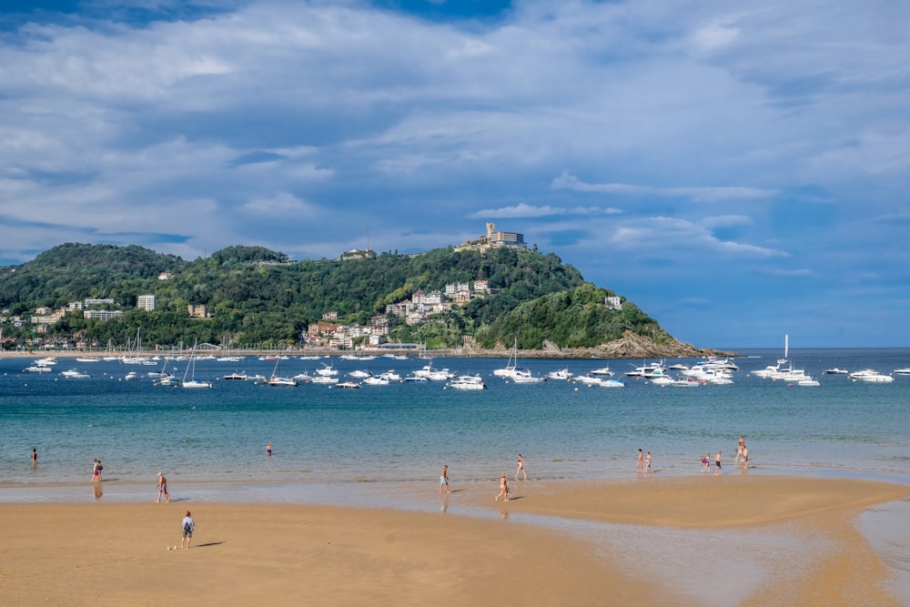 Una playa con gente y barcos