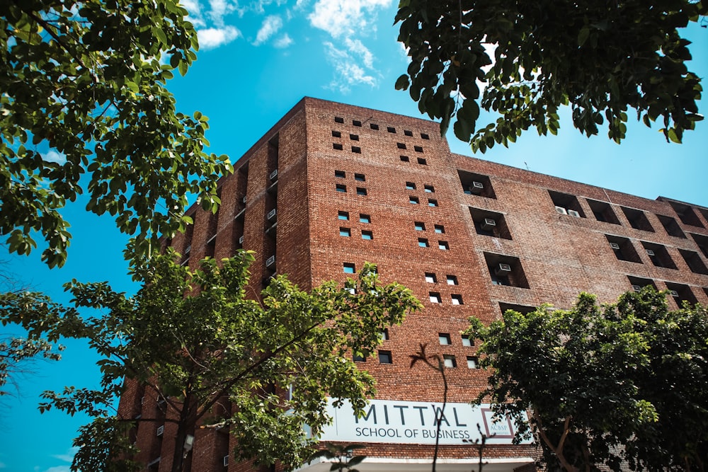 um edifício alto com árvores na frente dele