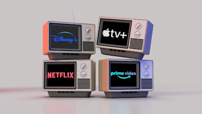 Four old-style television sets are stacked in two rows and each screen displays a different streaming service logo: Disney+, Apple TV+, Netflix, and Prime Video.
