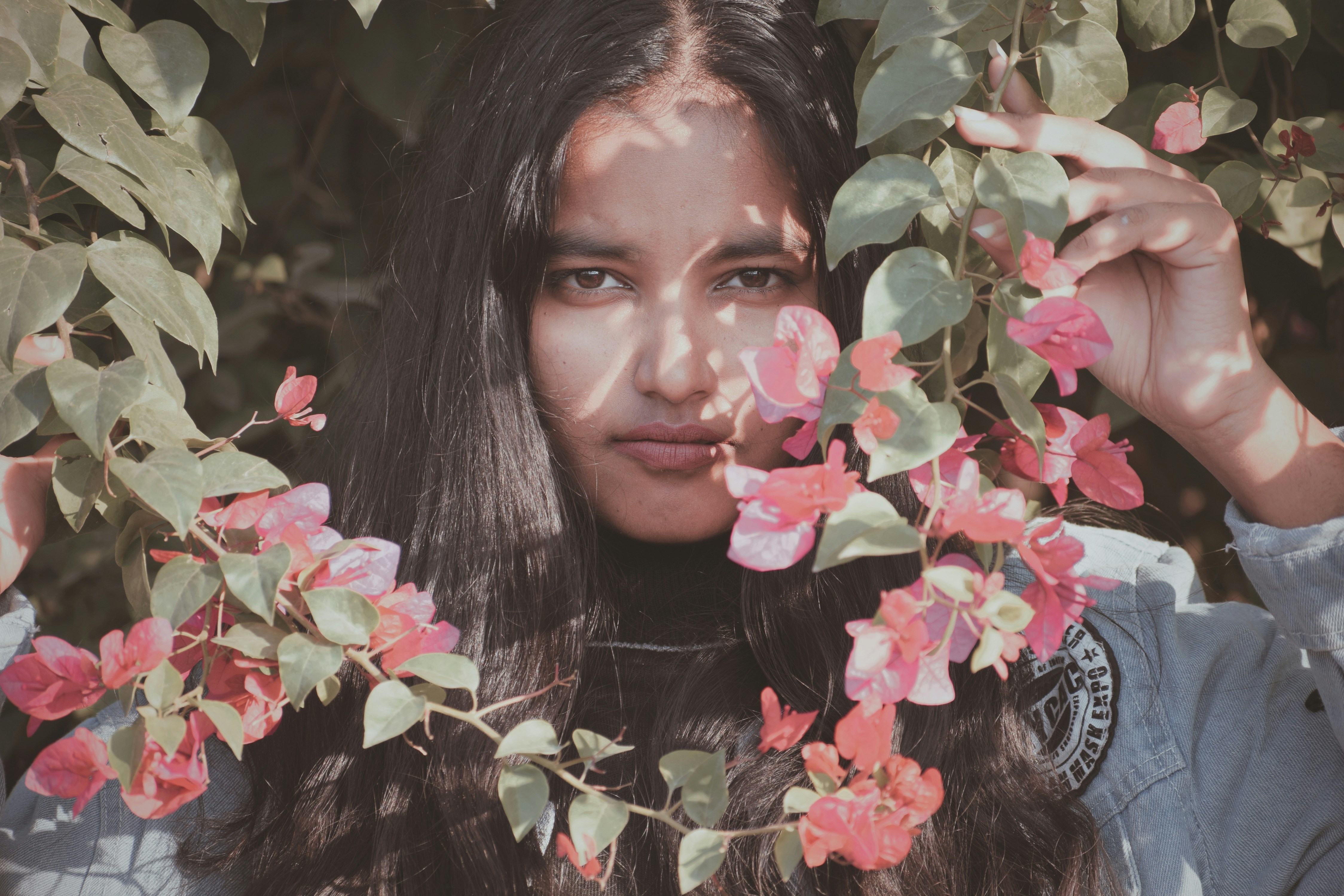 una persona con cabello largo sosteniendo una flor