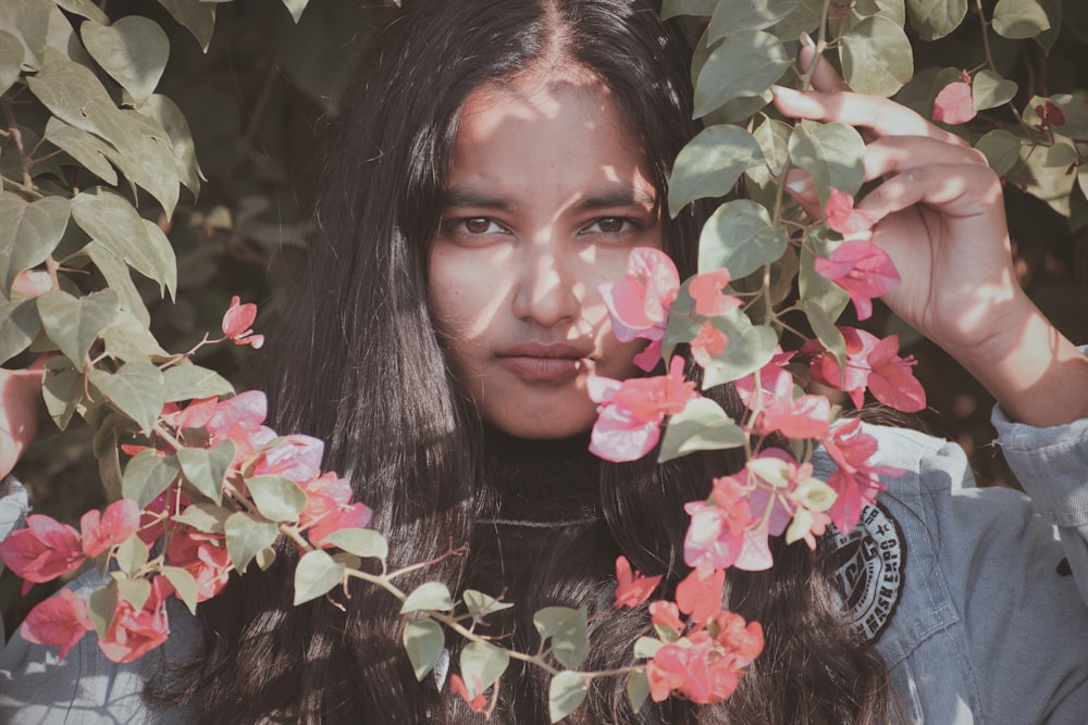 a person with long hair holding a flower