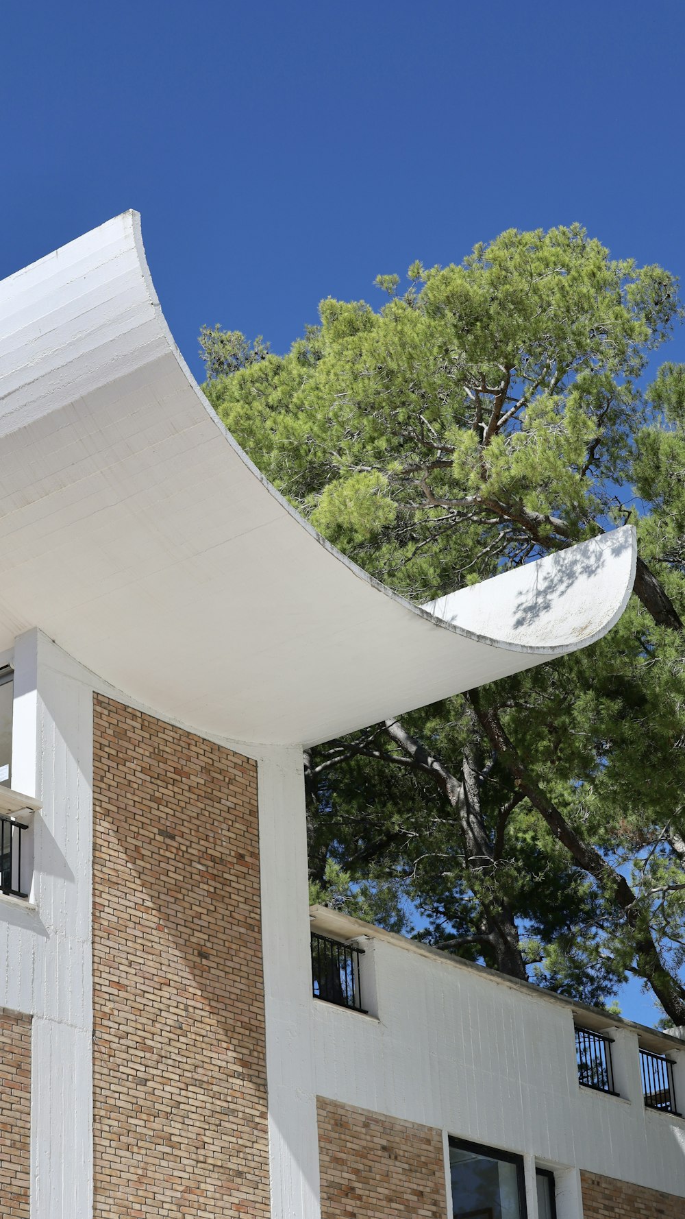 a white building with a tree in the background