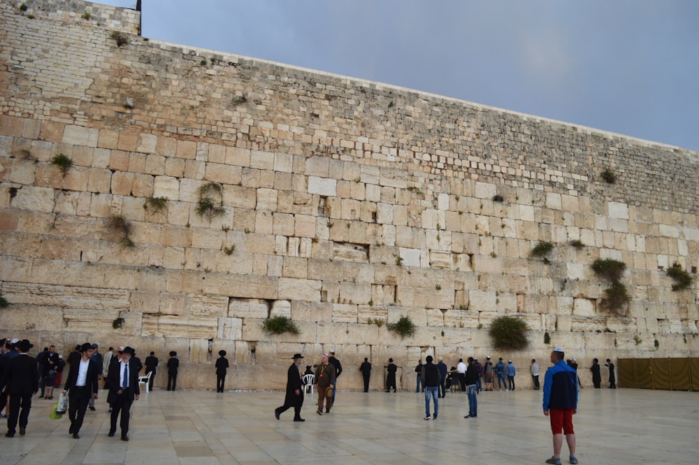 a group of people standing in front of a stone wall with Western Wall in the background