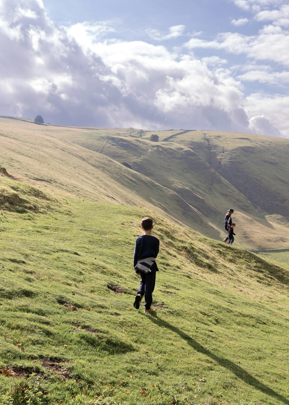 Un gruppo di persone che camminano su una collina erbosa