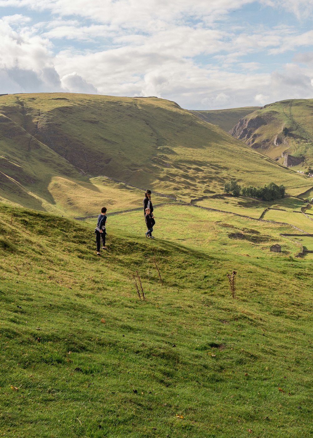 a group of people walking on a grassy hill