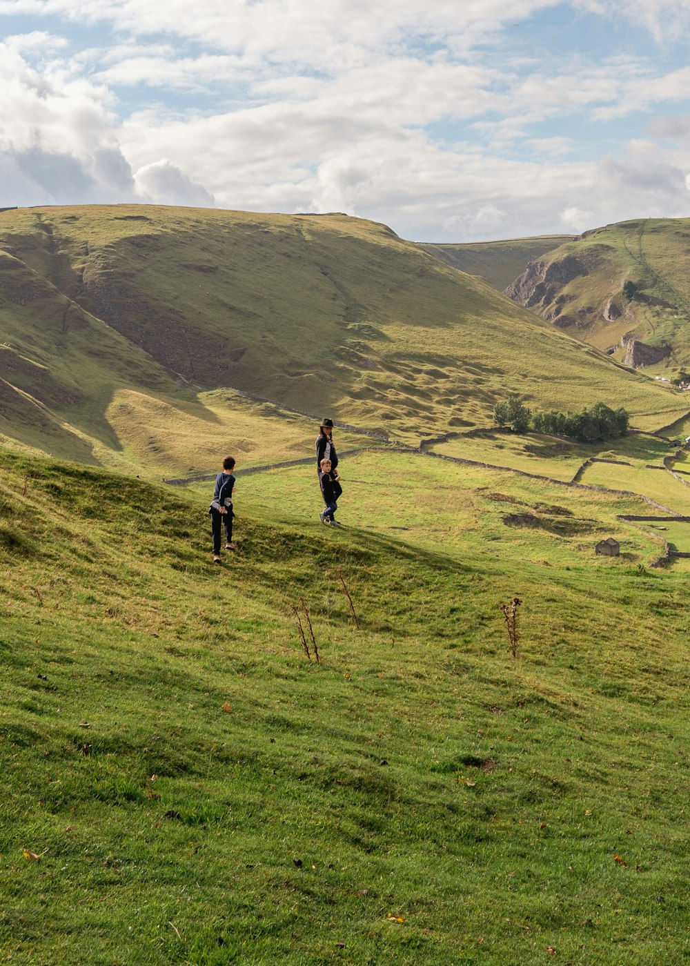 Un gruppo di persone che camminano su una collina erbosa