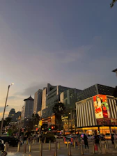 A dynamic street scene at dusk with young people wearing bold Urbanpulse streetwear, neon lights glowing in the background.