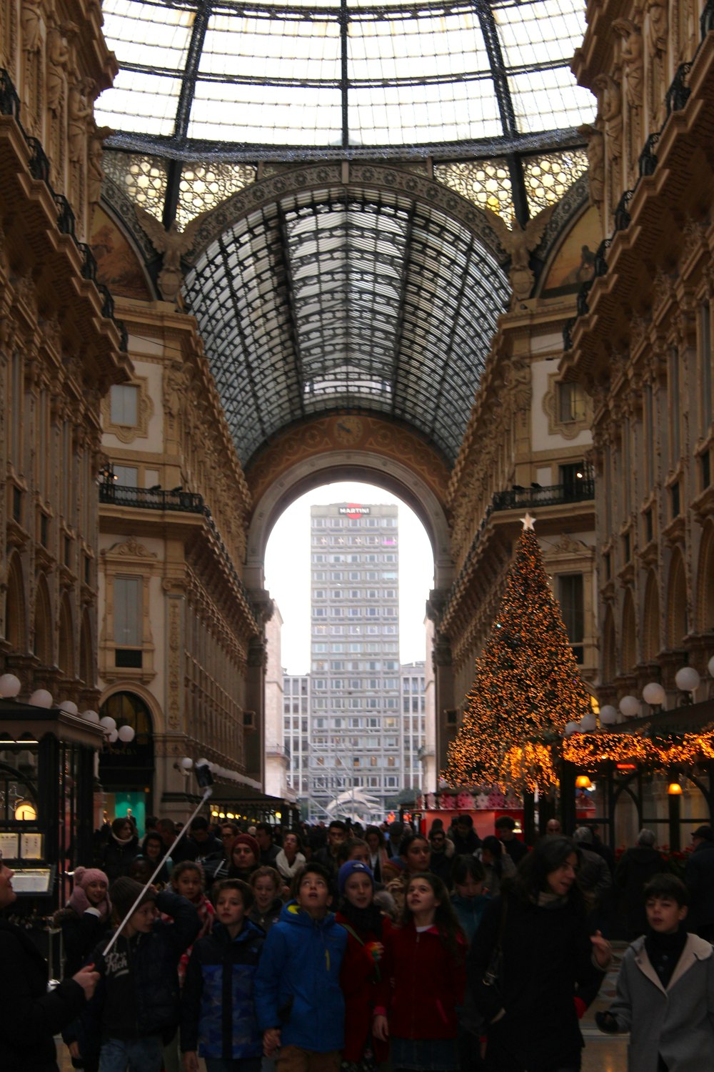 a group of people in a large building with a large christmas tree