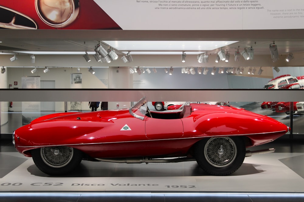 Une voiture de sport rouge dans une salle d’exposition