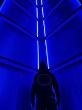 Futuristic scientist Captain Giroxx standing next to a glowing blue neon communication device.
