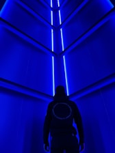 A futuristic hospital corridor illuminated with soft indigo and blue lighting, showcasing advanced medical technology.