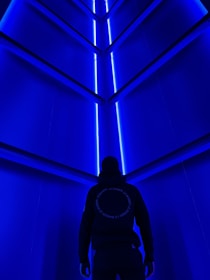 A futuristic hospital corridor illuminated with soft indigo and blue lighting, showcasing advanced medical technology.