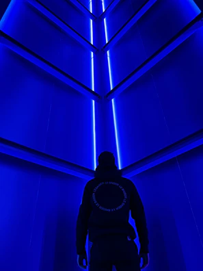 Futuristic office corridor illuminated with blue and cyan ambient lighting.