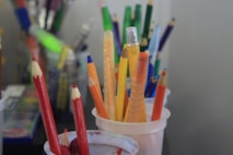 a cup full of colored pencils