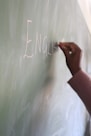 a hand writing on a chalkboard