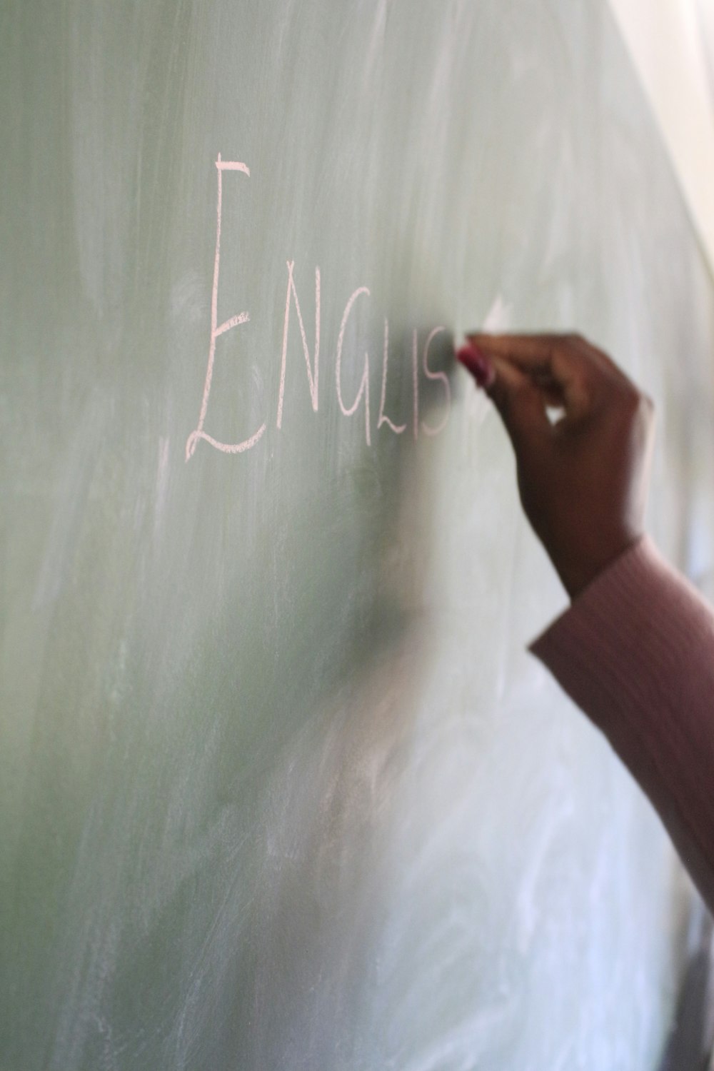 a hand writing on a chalkboard