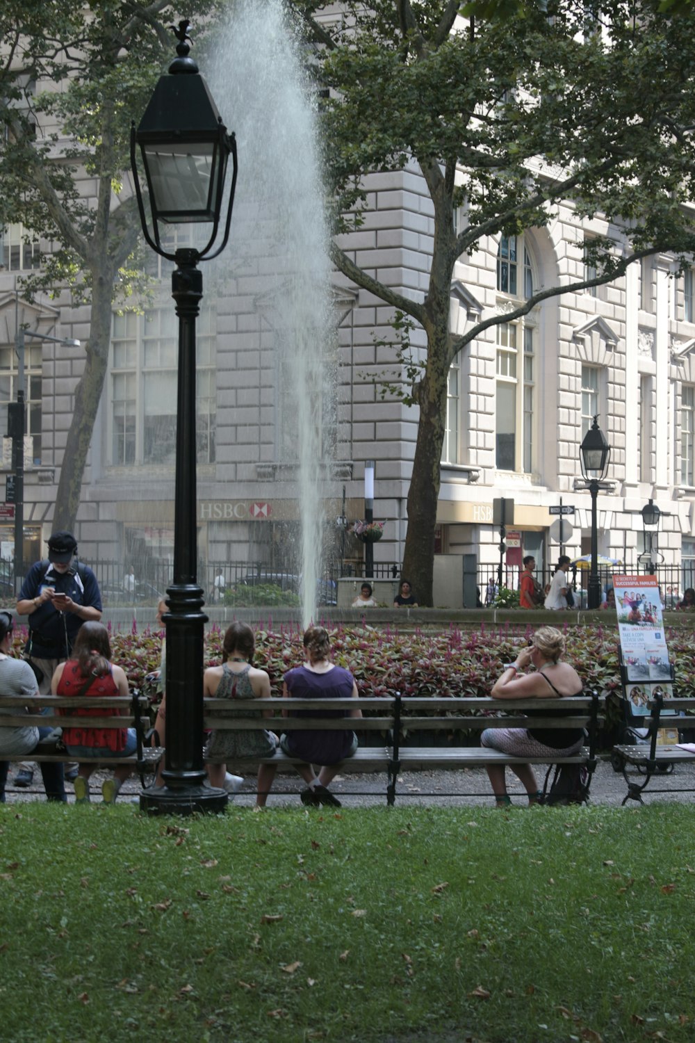 people sitting on benches in a park