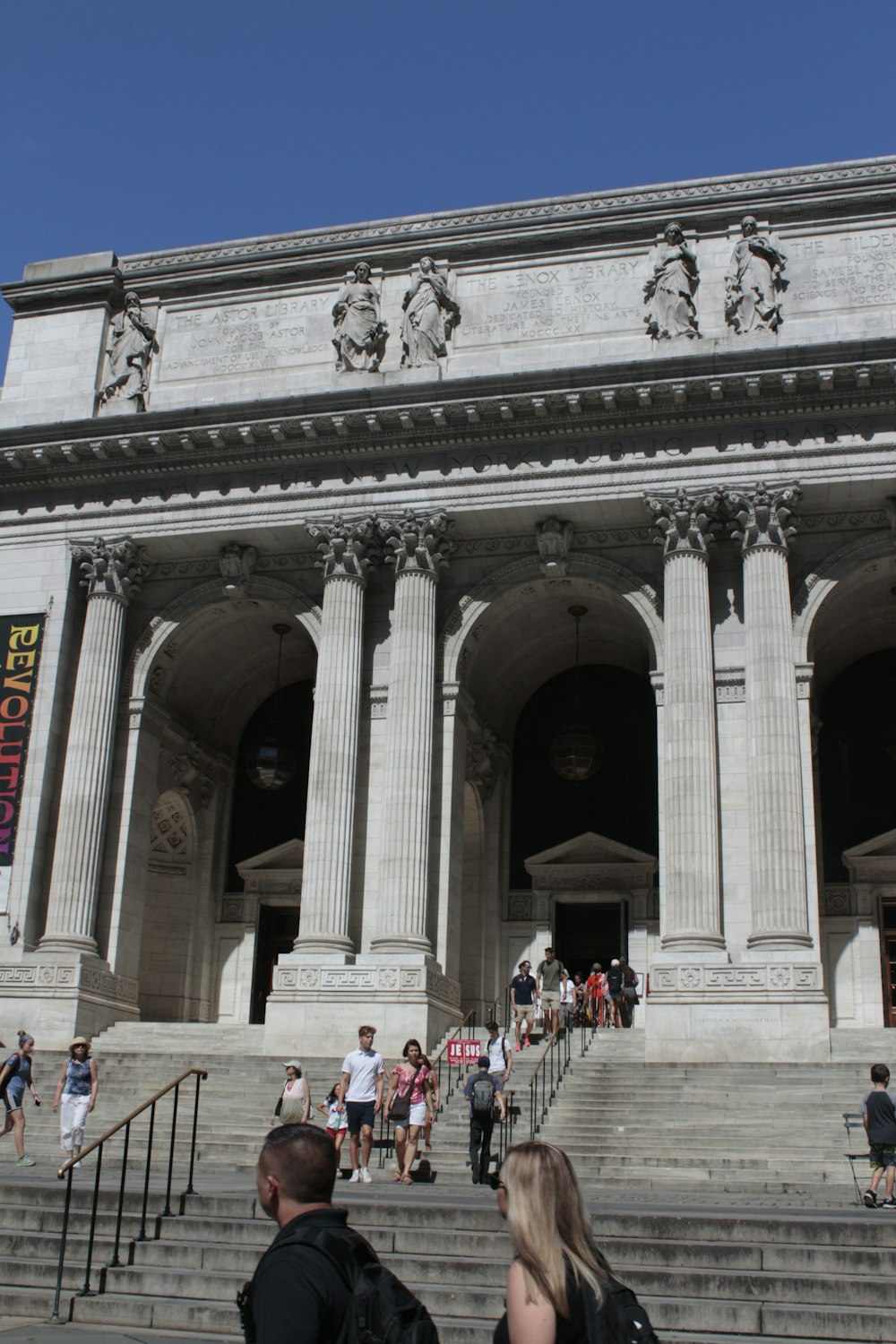 people walking up stairs to New York Public Library