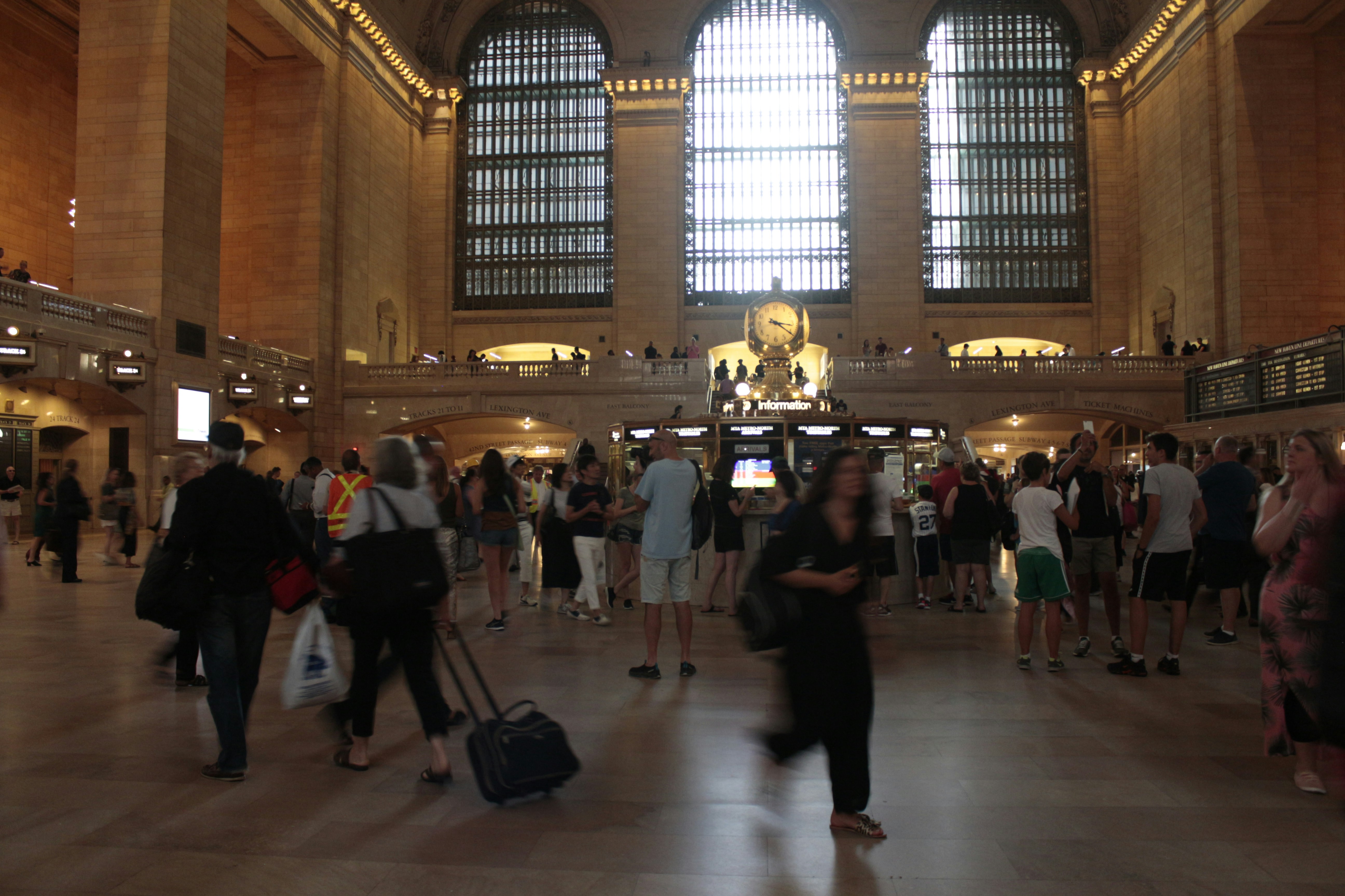 sekelompok besar orang di sebuah gedung besar dengan Grand Central Terminal di latar belakang