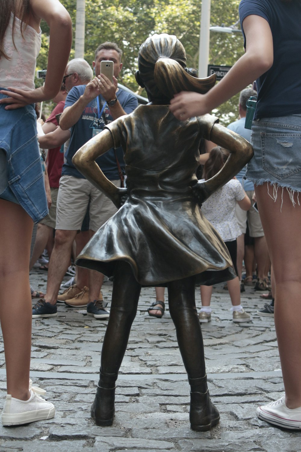 a woman taking a picture of a statue of a woman