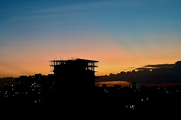 A time-lapse shot of a sustainable building rising amidst a city skyline at sunset.