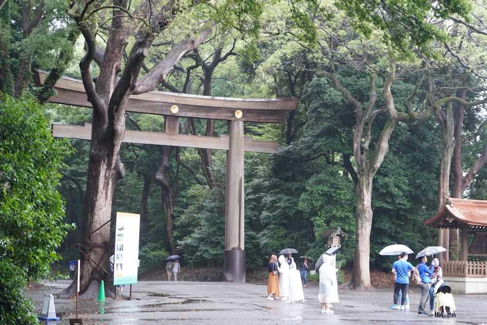 a group of people walking under a wooden arch