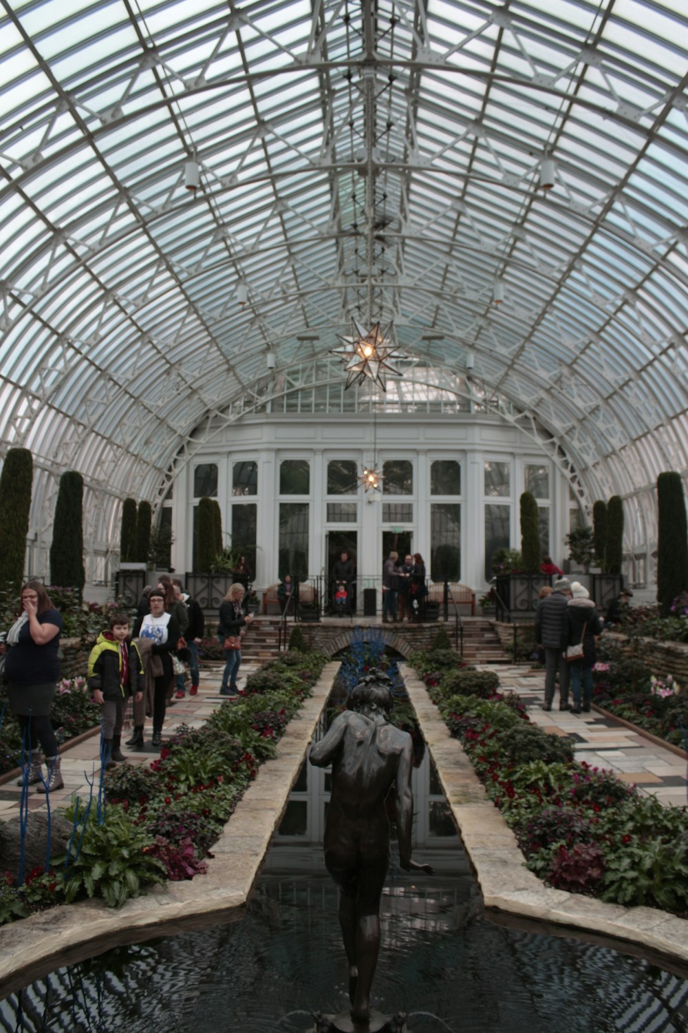 a large building with a large glass ceiling and a statue in front with Como Park Zoo and Conservatory in the background