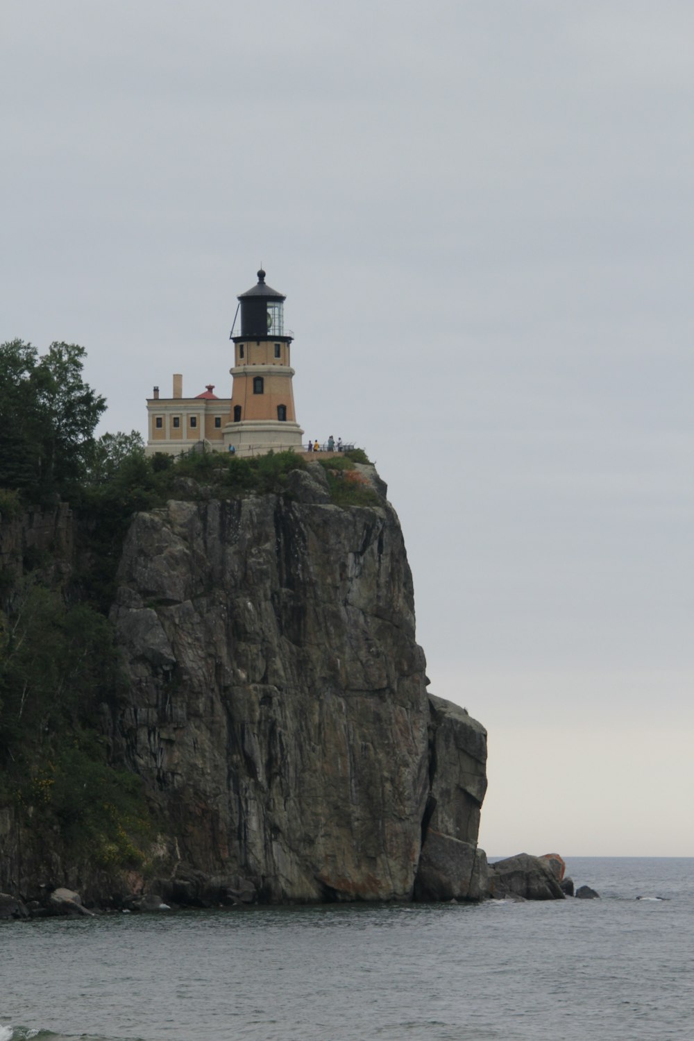 a lighthouse on a rocky cliff with Split Rock Lighthouse in the background