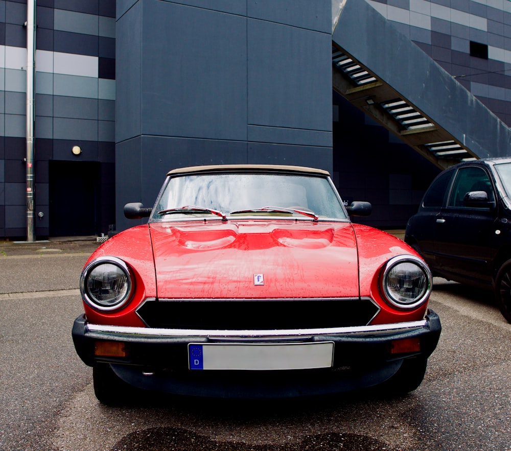 a red car parked in front of a building