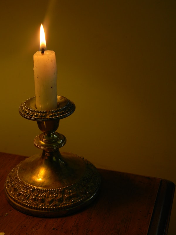 Une bougie et une vieille carte sur une table