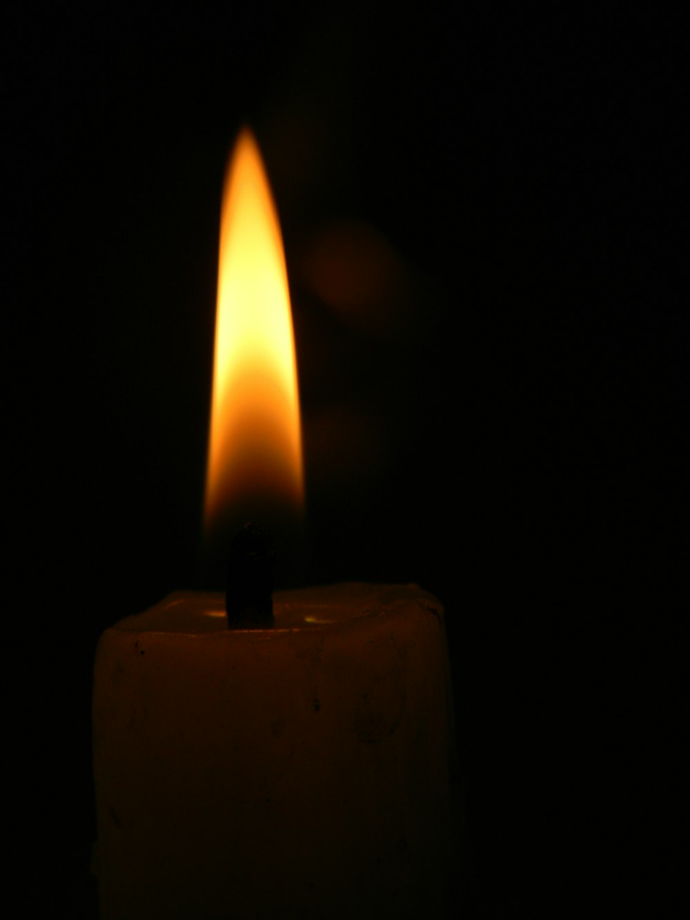 a lit candle in a dark room