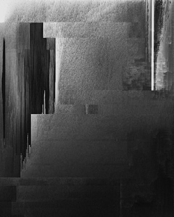 A grayscale abstract composition with a mix of vertical and horizontal lines and textures creating a sense of depth and movement. The image has a digital glitch-like appearance with fragmented and pixelated areas.
