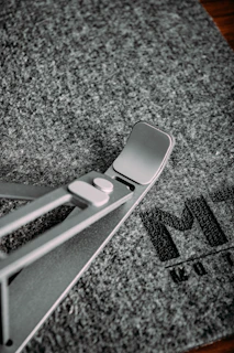 Futuristic 3D printed phone stand in gold accent color on a matte black surface