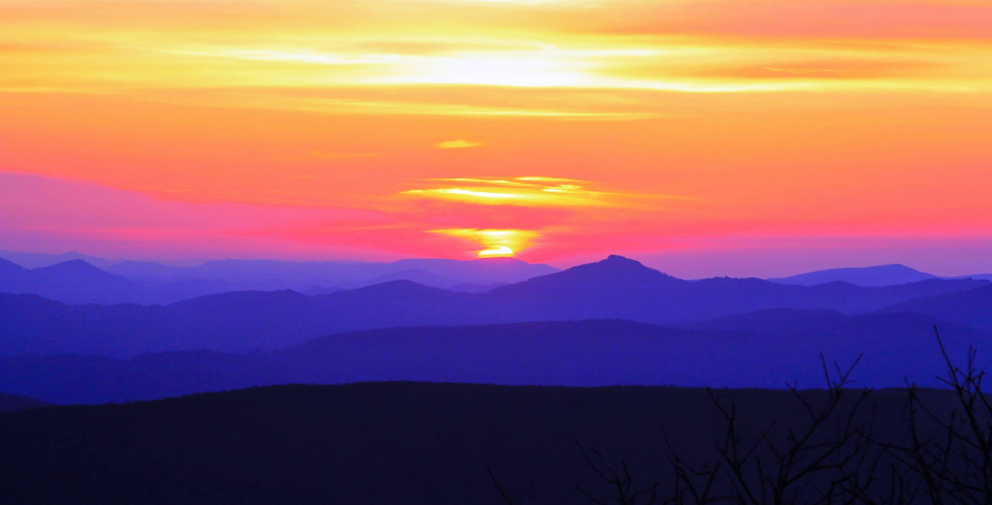 a sunset over a mountain range