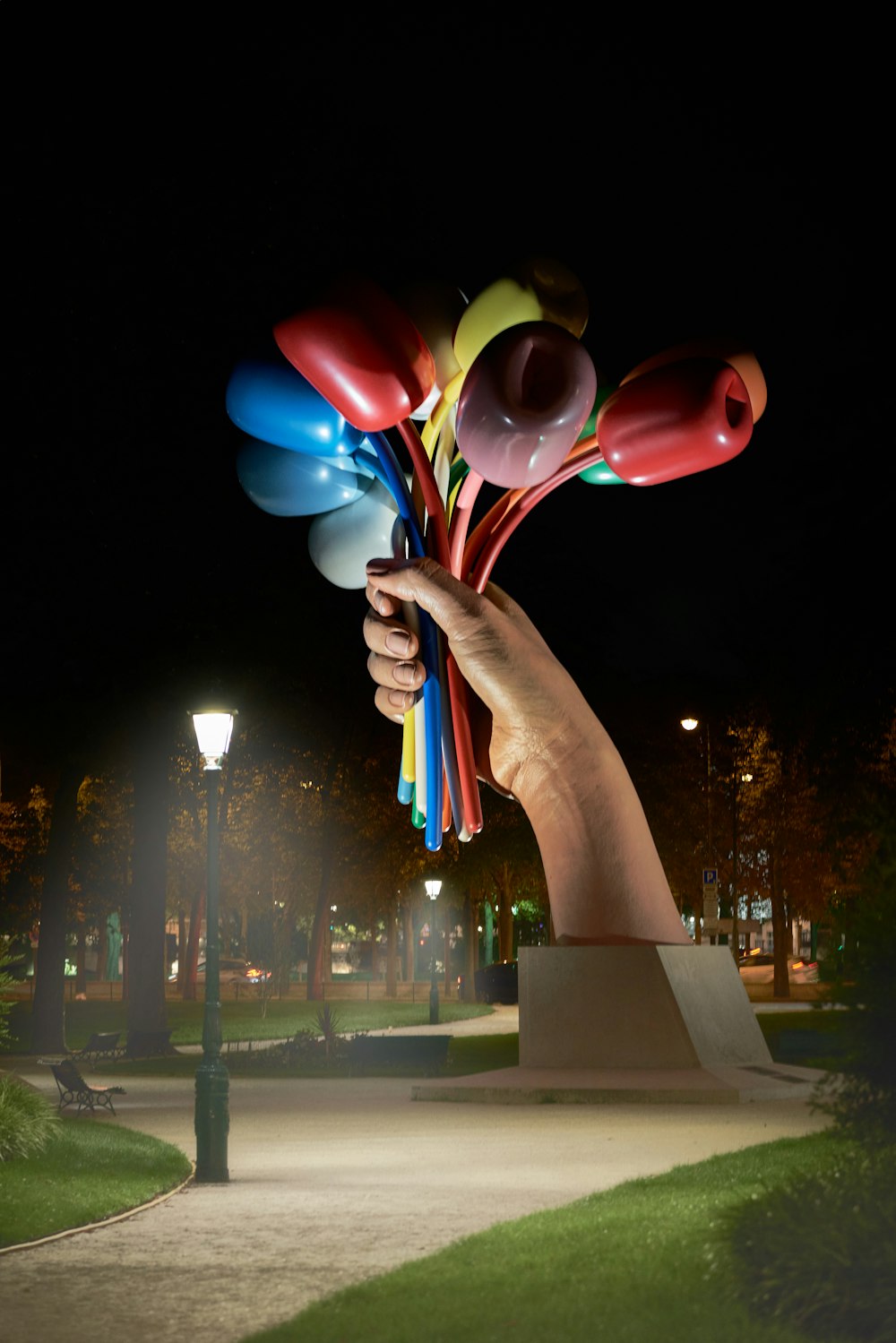 una statua di una persona che tiene palloncini