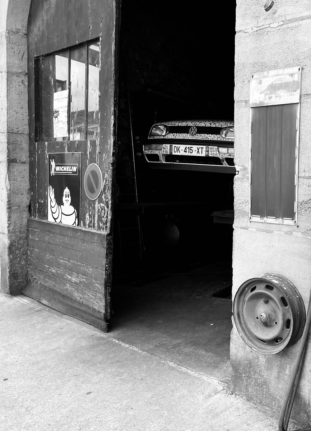 a black and white photo of a car parked in front of a building