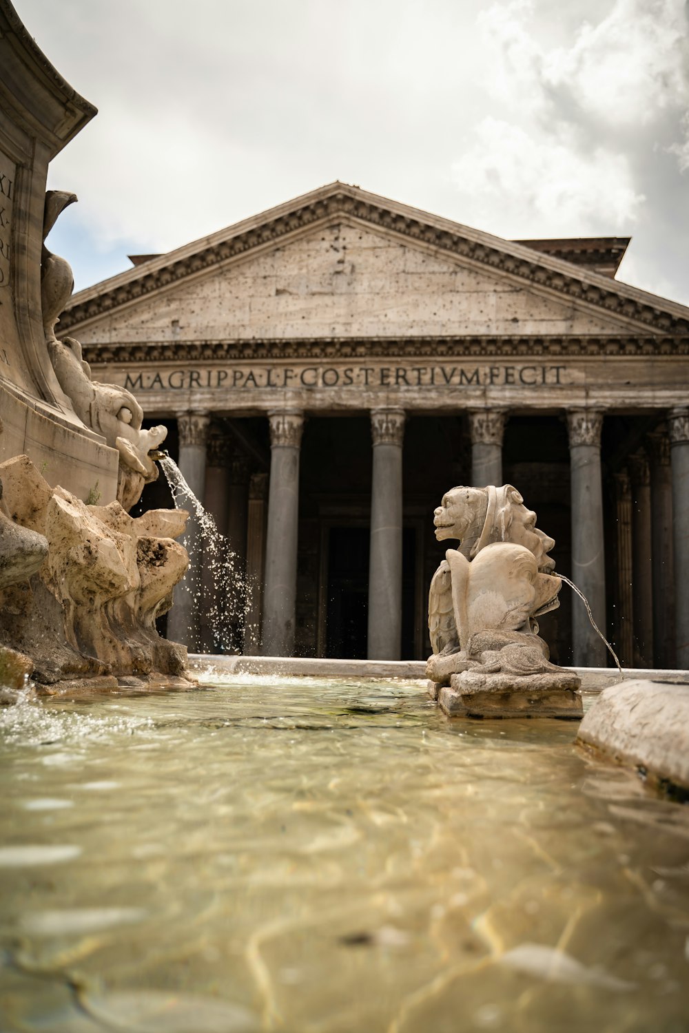 a fountain with statues in front of a building