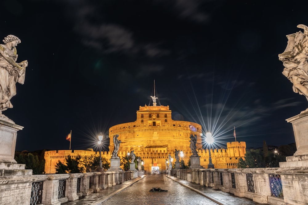 a large building with a gold dome and statues at night