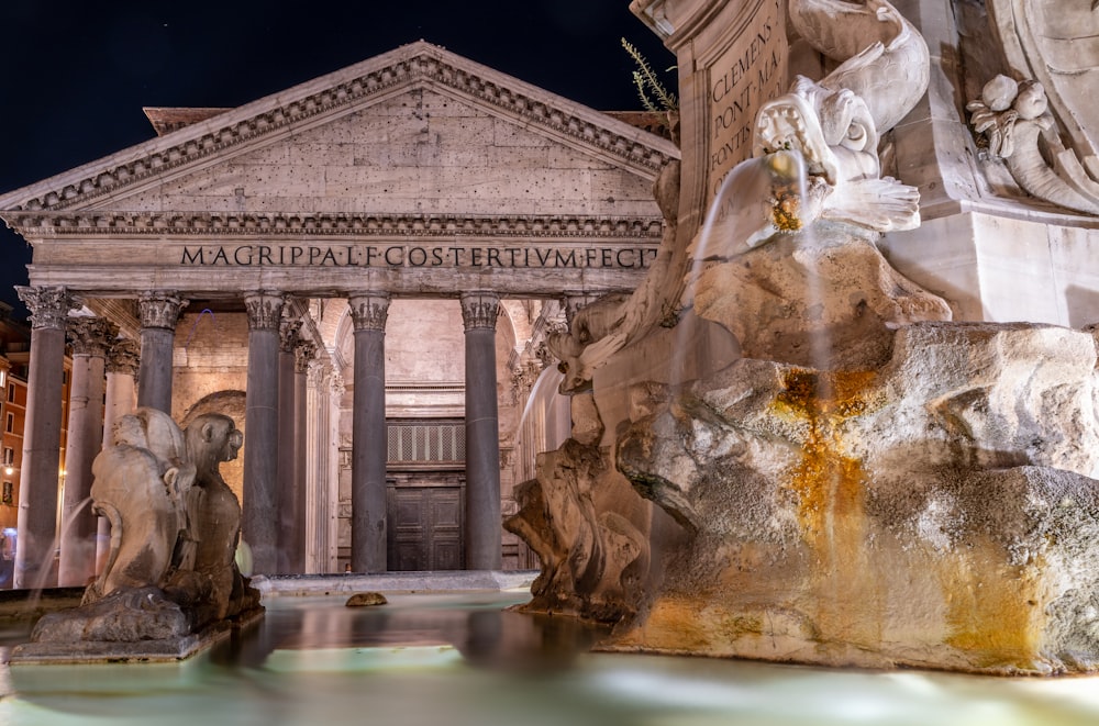 a fountain with statues in front of a building