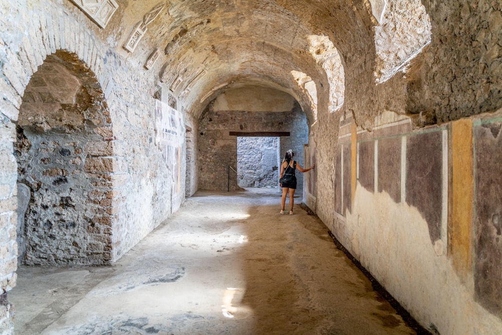 a person standing in a stone hallway