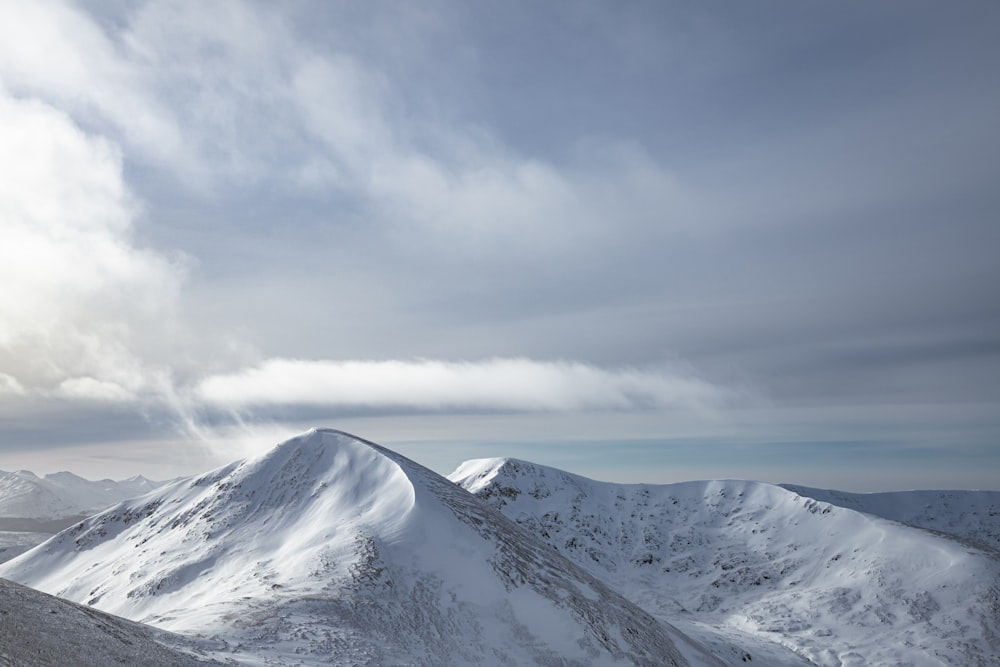 a snowy mountain with clouds