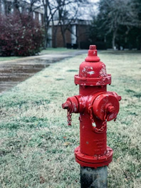 A technician servicing a frost free hydrant against a grey-blue cloudy sky.