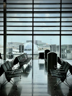 A sleek black and gold airport lounge entrance with comfortable seating visible inside.
