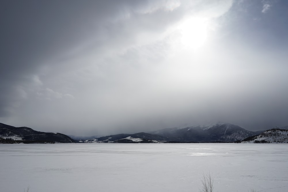 a snowy landscape with mountains in the background