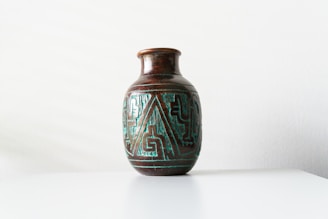 Handcrafted ceramic vase with intricate patterns on a wooden table.