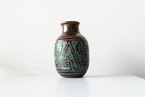 Close-up of a vibrant 3D printed decorative vase with intricate geometric patterns on a wooden table.