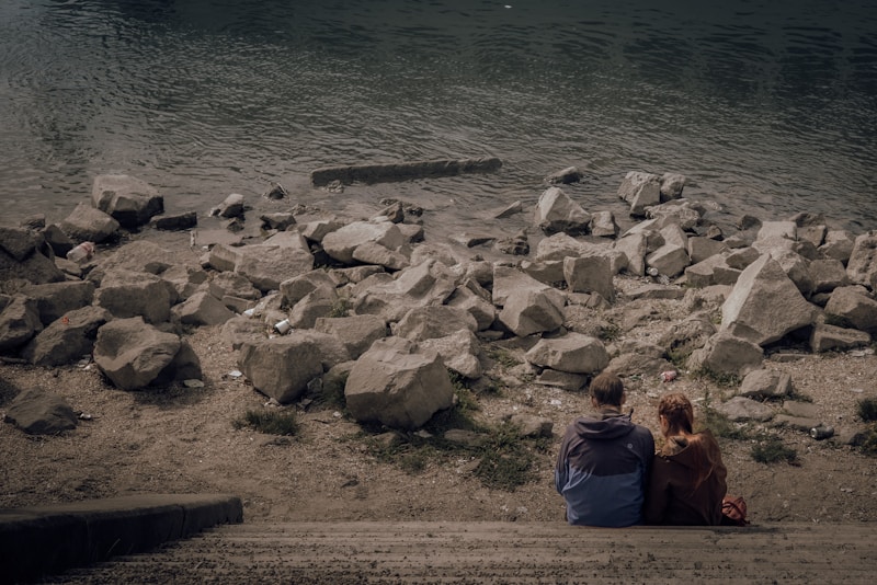 Pari istuu rantakivillä