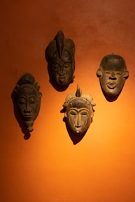 Close-up of traditional Balinese topeng masks displayed on a wooden wall.