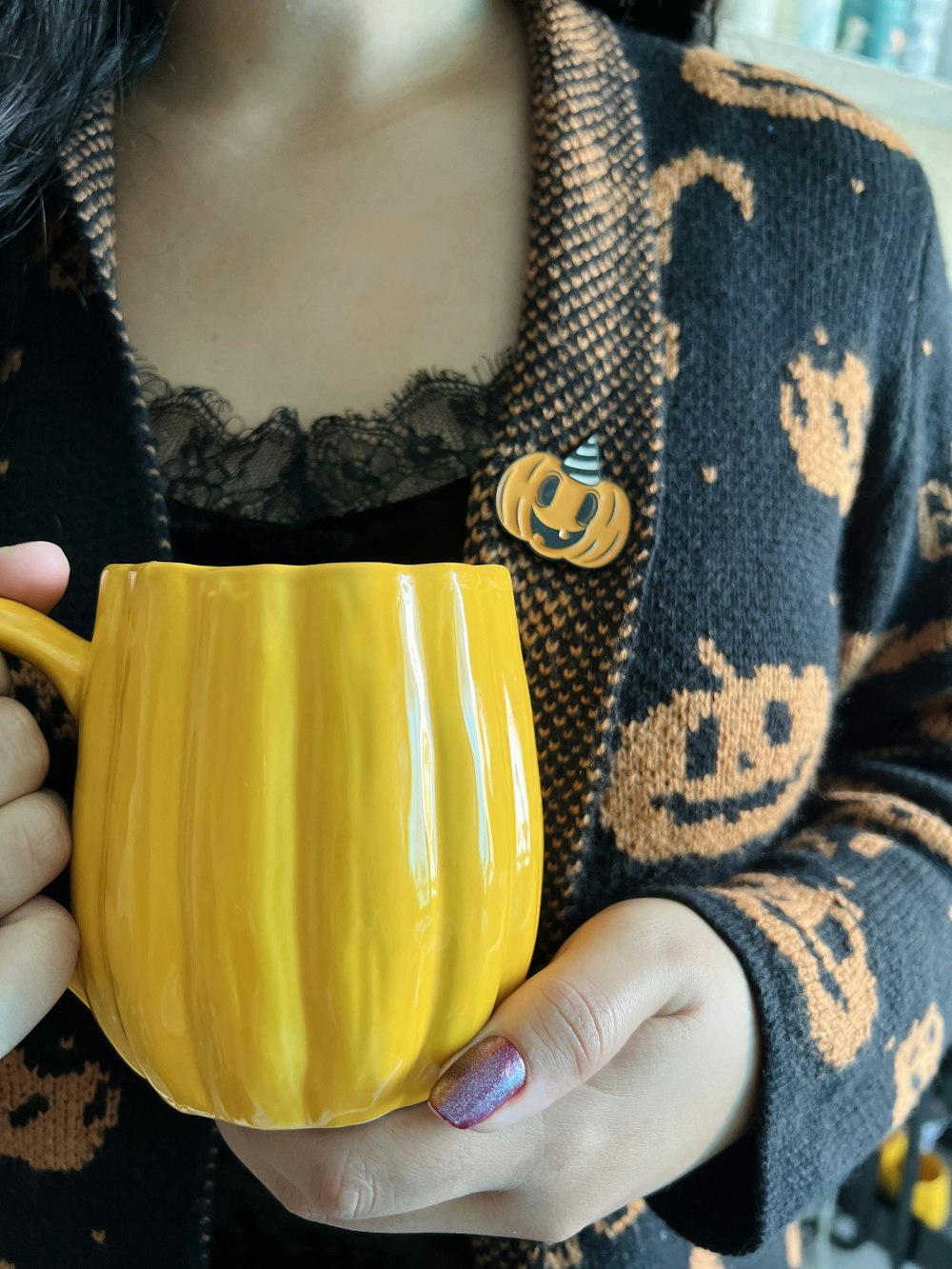 une personne tenant une tasse jaune