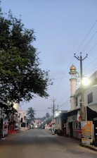 A serene street scene in Madinah with locals greeting each other warmly under soft morning light.